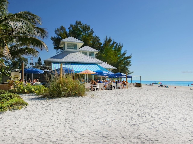 view of property's community featuring a water view and a beach view