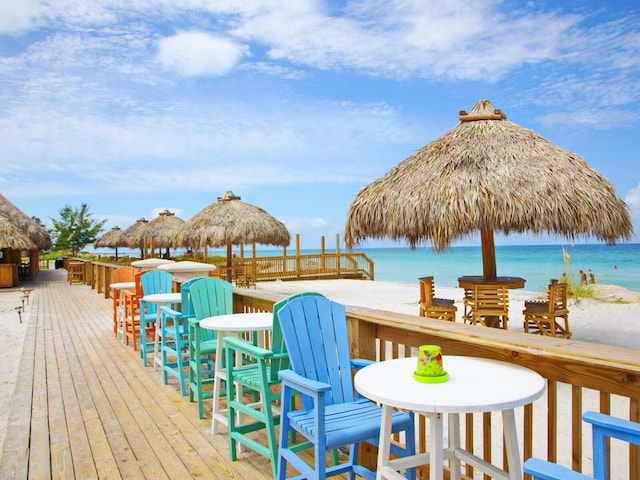 wooden deck with a gazebo, outdoor dining area, and a water view