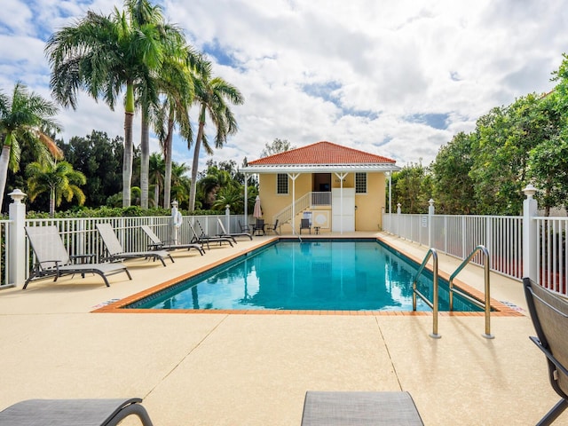 pool featuring fence and a patio area