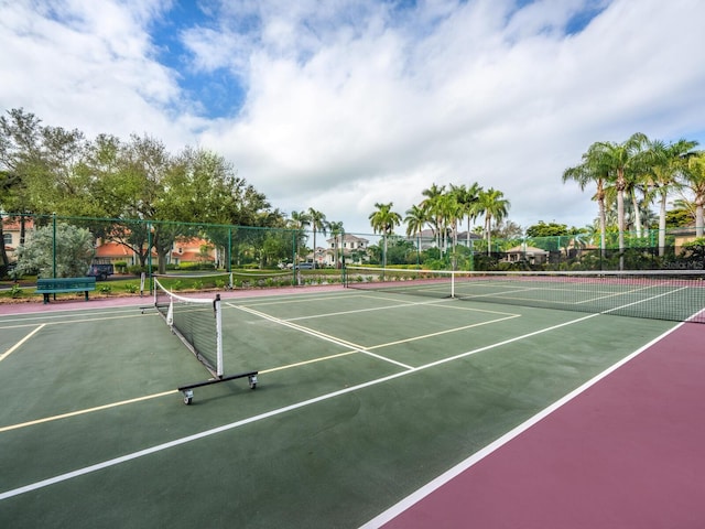 view of tennis court with community basketball court and fence