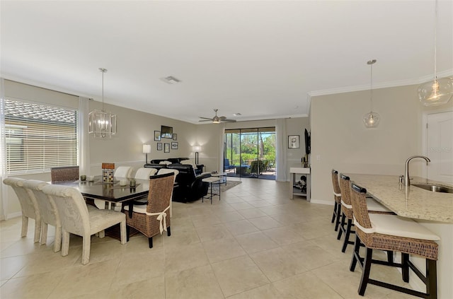 dining area featuring light tile patterned floors, ornamental molding, ceiling fan with notable chandelier, baseboards, and visible vents