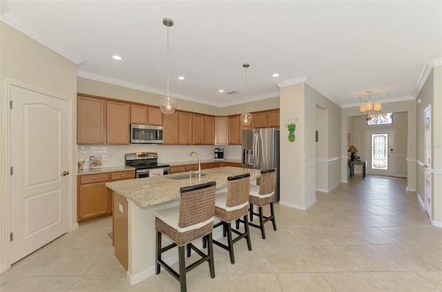 kitchen featuring an island with sink, light tile patterned floors, a sink, and stainless steel appliances