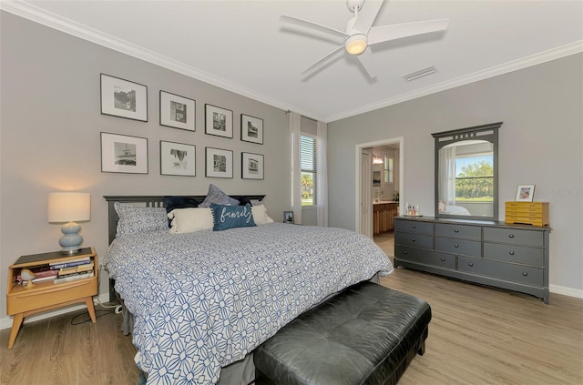 bedroom with crown molding, multiple windows, light wood finished floors, and visible vents