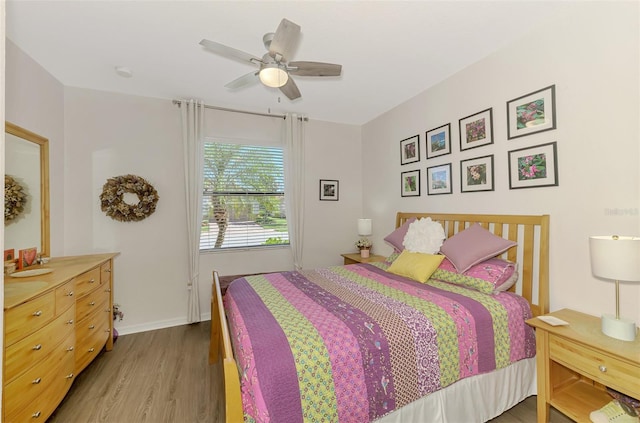 bedroom with baseboards, wood finished floors, and a ceiling fan