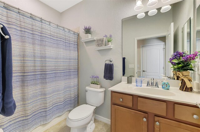 bathroom with a shower with curtain, tile patterned flooring, vanity, toilet, and baseboards