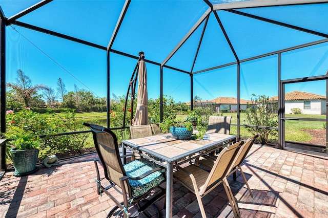 view of patio featuring glass enclosure and outdoor dining area