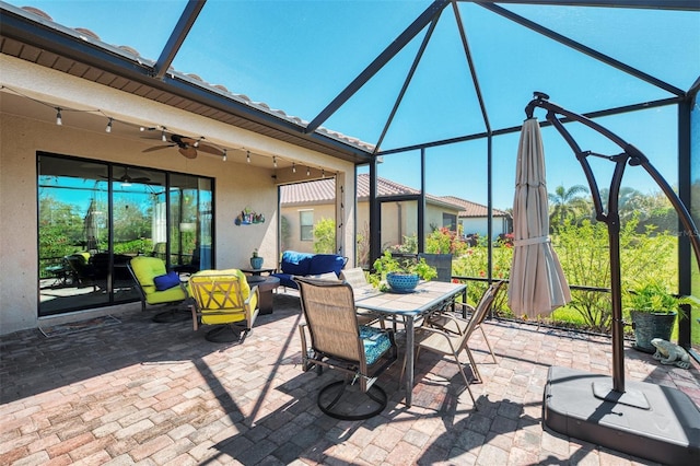 view of patio / terrace featuring glass enclosure, an outdoor hangout area, outdoor dining space, and a ceiling fan