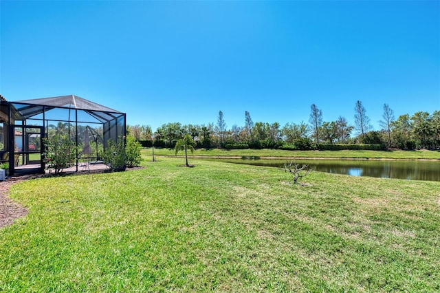 view of yard with glass enclosure and a water view