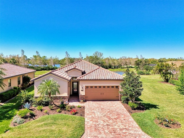 mediterranean / spanish home featuring a tile roof, stucco siding, an attached garage, decorative driveway, and a front yard