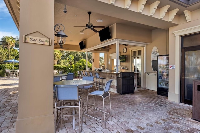 view of patio with outdoor dry bar, outdoor dining area, and ceiling fan