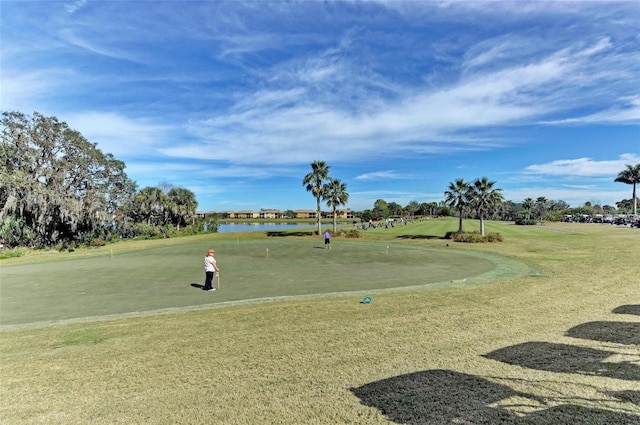 view of home's community featuring golf course view, a water view, and a lawn