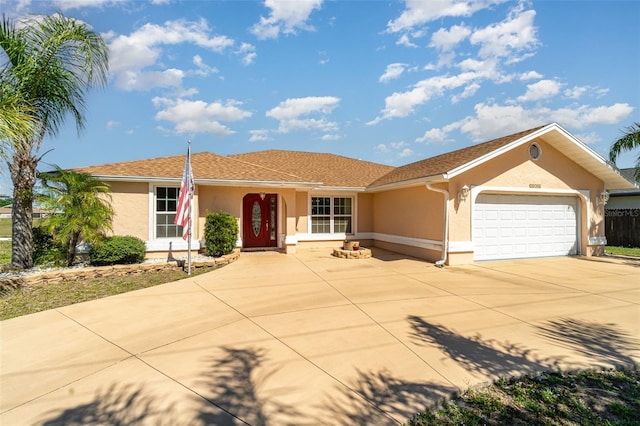 ranch-style home with stucco siding, a garage, and driveway
