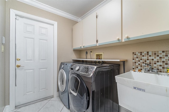 clothes washing area with a sink, cabinet space, separate washer and dryer, and crown molding