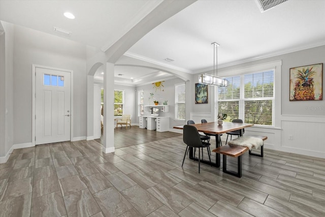 5954 Anise Dr, Sarasota, FL 34238 - dining room featuring arched walkways, plenty of natural light, recessed lighting, ornamental molding, and a wainscoted wall