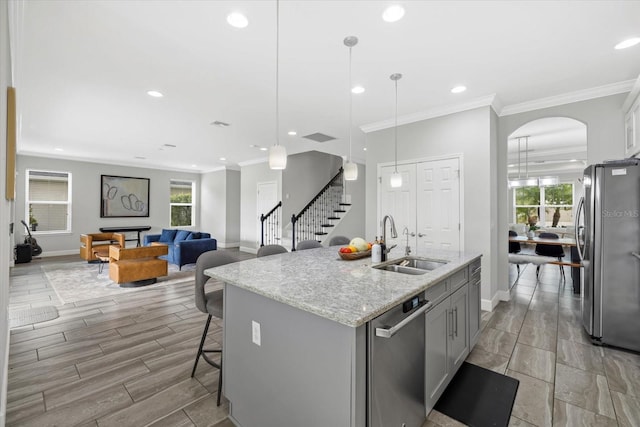 5954 Anise Dr, Sarasota, FL 34238 - kitchen with appliances with stainless steel finishes, recessed lighting, light stone counters, an island with sink, and ornamental molding