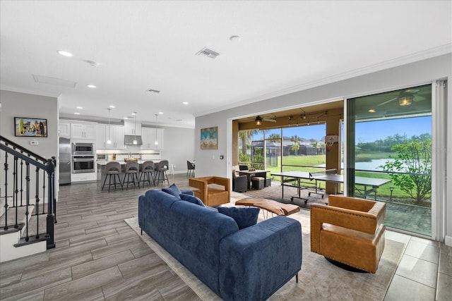 5954 Anise Dr, Sarasota, FL 34238 - living room featuring ornamental molding, stairway, ceiling fan, recessed lighting, and a water view