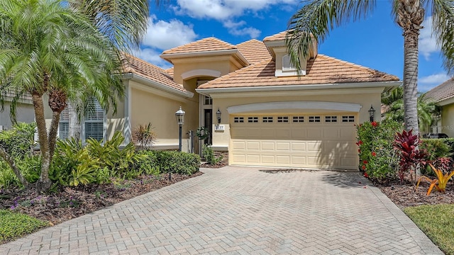 7137 Orchid Island Pl, Bradenton, FL 34202 - mediterranean / spanish home with a garage, stucco siding, a tiled roof, and decorative driveway