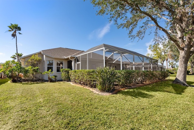 2439 Sonoma Dr W, Nokomis, FL 34275 - back of house with a yard, glass enclosure, and stucco siding