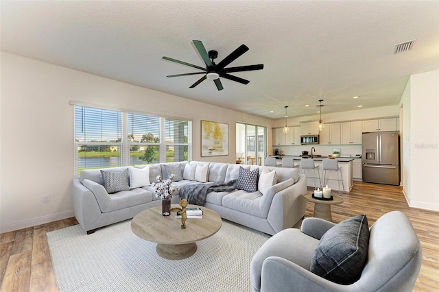 10614 Morning Marsh Ln, Parrish, FL 34219 - living room with baseboards, light wood finished floors, ceiling fan, recessed lighting, and a water view