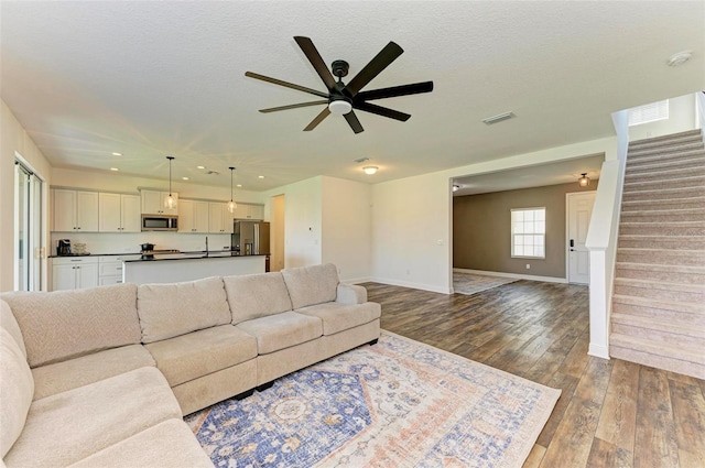 10614 Morning Marsh Ln, Parrish, FL 34219 - living room featuring a ceiling fan, stairs, dark wood finished floors, and recessed lighting