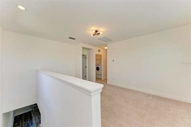 10614 Morning Marsh Ln, Parrish, FL 34219 - spare room featuring washer / dryer, light carpet, and a multi sided fireplace