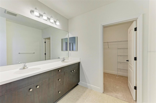10614 Morning Marsh Ln, Parrish, FL 34219 - full bathroom with double vanity, a walk in closet, and tile patterned flooring