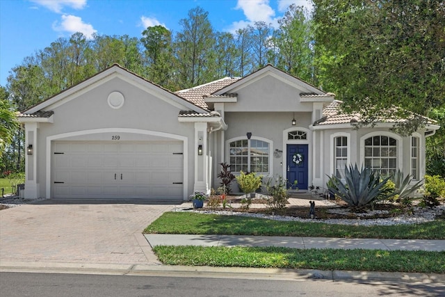 259 Golden Harbour Trl, Bradenton, FL 34212 - view of front of property featuring a tile roof, decorative driveway, an attached garage, and stucco siding
