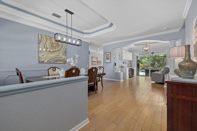 259 Golden Harbour Trl, Bradenton, FL 34212 - interior space with visible vents, a tray ceiling, light wood-style flooring, arched walkways, and ornate columns