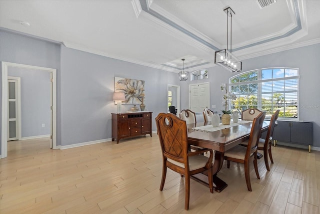 259 Golden Harbour Trl, Bradenton, FL 34212 - dining space with crown molding, baseboards, a raised ceiling, and light wood-style floors