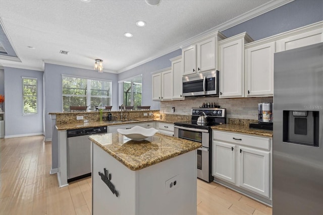 259 Golden Harbour Trl, Bradenton, FL 34212 - kitchen featuring decorative backsplash, a peninsula, appliances with stainless steel finishes, and ornamental molding