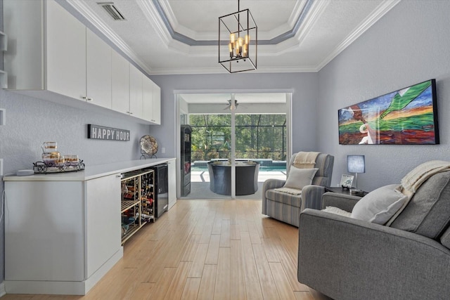 259 Golden Harbour Trl, Bradenton, FL 34212 - living area featuring visible vents, ornamental molding, light wood-style floors, a raised ceiling, and a textured wall