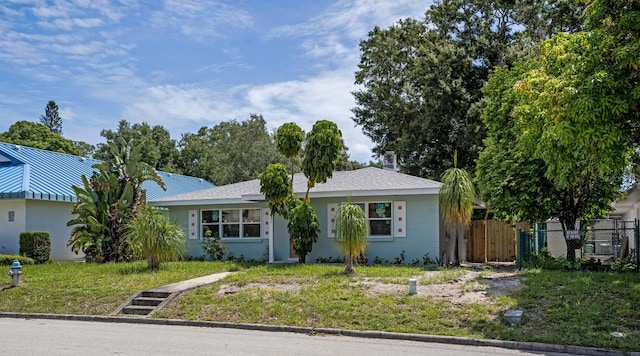 ranch-style house featuring stucco siding, fence, and a front yard