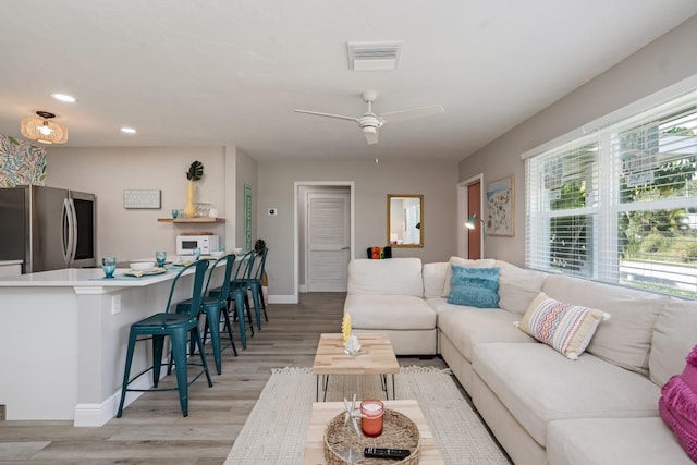 living area with recessed lighting, baseboards, light wood finished floors, visible vents, and a ceiling fan
