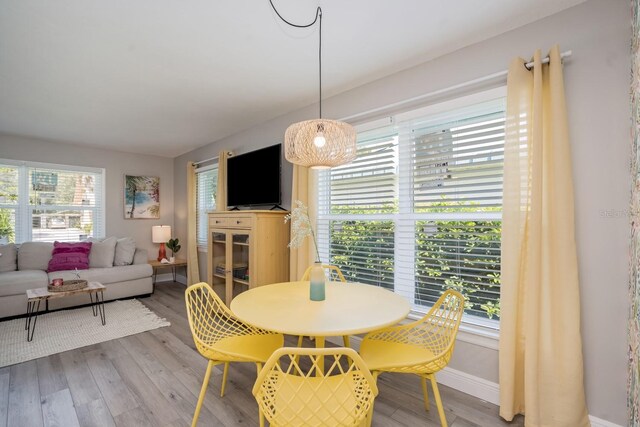 dining area with baseboards and wood finished floors