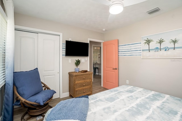 bedroom featuring visible vents, a closet, wood finished floors, and ceiling fan
