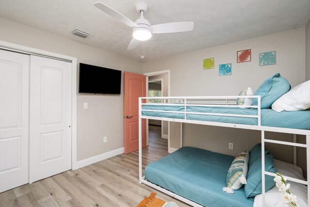 bedroom featuring a closet, visible vents, baseboards, ceiling fan, and light wood-type flooring