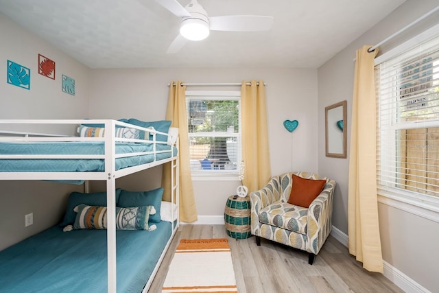 bedroom featuring a ceiling fan, baseboards, and wood finished floors