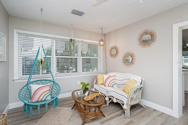 sitting room with wood finished floors, baseboards, and visible vents