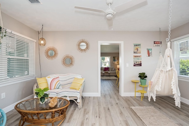 sitting room featuring plenty of natural light, baseboards, and light wood finished floors