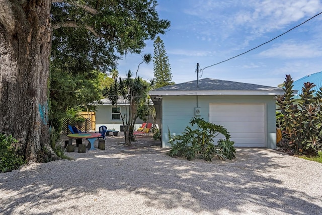 exterior space with gravel driveway, an outbuilding, and a garage