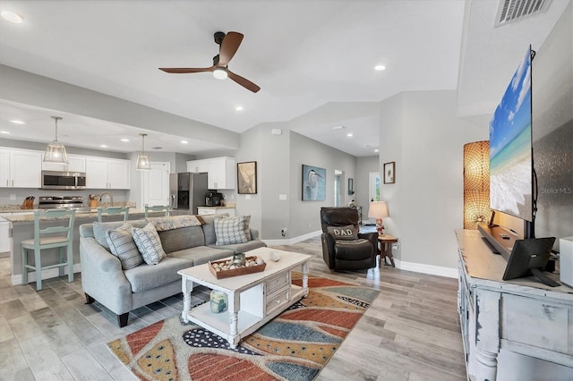 145 Baytree Dr, Rotonda West, FL 33947 - living room with ceiling fan, light wood-style floors, baseboards, lofted ceiling, and recessed lighting