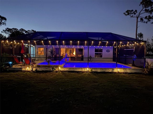 145 Baytree Dr, Rotonda West, FL 33947 - back of house at night with an outdoor pool