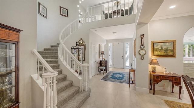 foyer entrance featuring recessed lighting, baseboards, stairs, and a high ceiling
