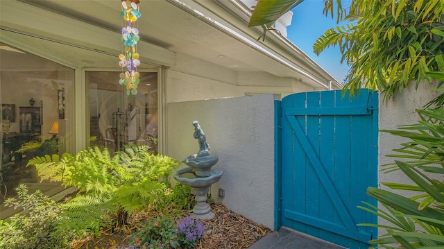 entrance to property featuring stucco siding and a gate