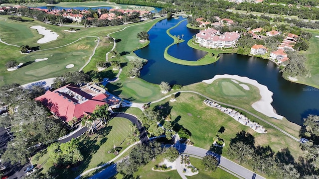 birds eye view of property with view of golf course and a water view