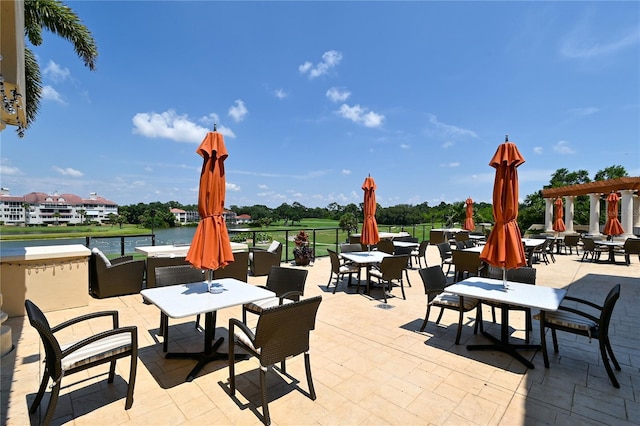 view of patio featuring a water view and outdoor dining space