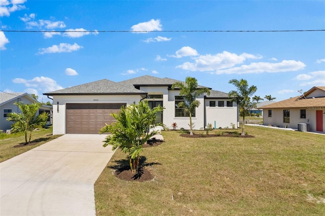 prairie-style house with cooling unit, stucco siding, an attached garage, driveway, and a front yard