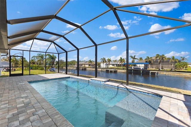 outdoor pool featuring glass enclosure, a water view, and a patio area