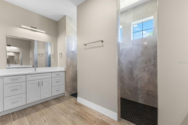 full bathroom with wood finished floors, vanity, and a walk in shower