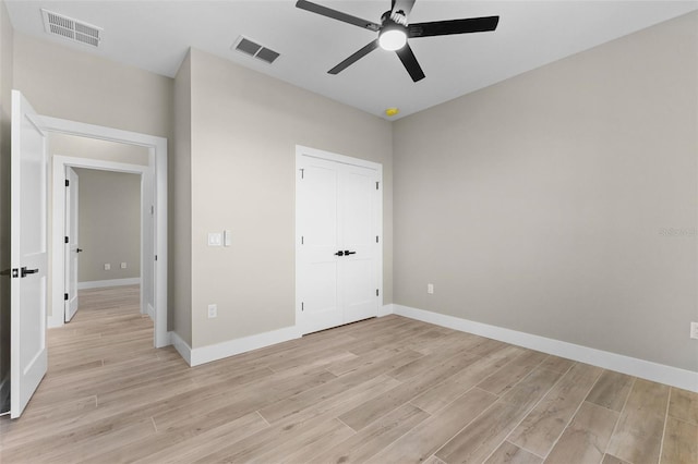 unfurnished bedroom featuring baseboards, light wood-style floors, and visible vents